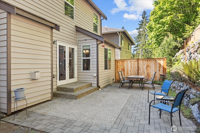 view of patio featuring french doors, outdoor dining area, and fence