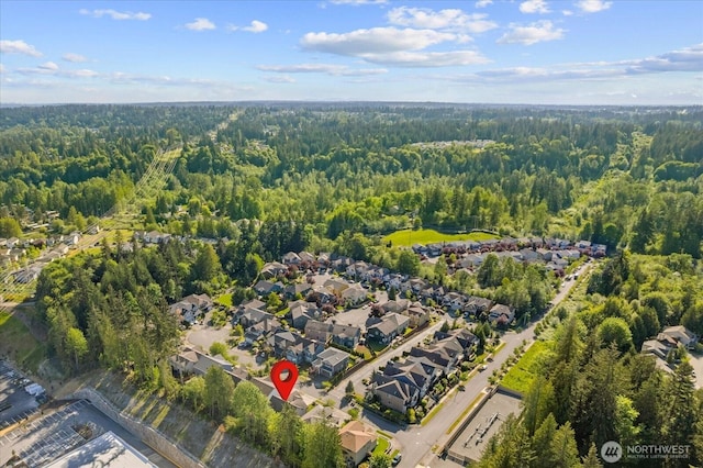 aerial view of property's location with a forest and nearby suburban area