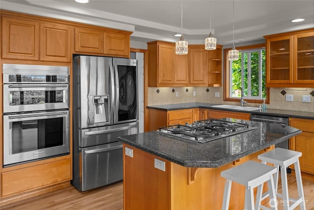 26901 15th Ave NE, Arlington, WA 98223 - kitchen with appliances with stainless steel finishes, brown cabinetry, light wood-style floors, a breakfast bar, and recessed lighting