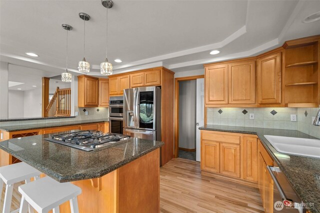 26901 15th Ave NE, Arlington, WA 98223 - kitchen featuring appliances with stainless steel finishes, a tray ceiling, a kitchen breakfast bar, decorative backsplash, and recessed lighting