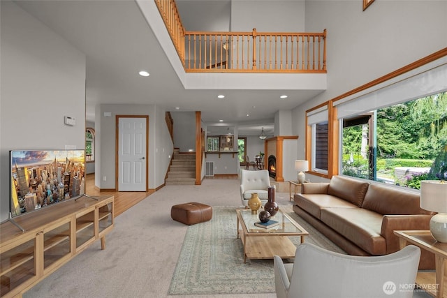 26901 15th Ave NE, Arlington, WA 98223 - living area featuring stairs, a high ceiling, recessed lighting, carpet floors, and a warm lit fireplace