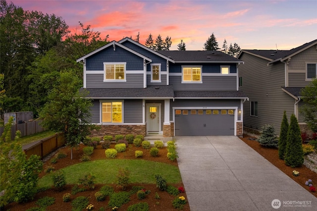 craftsman-style home featuring driveway, an attached garage, stone siding, and roof with shingles