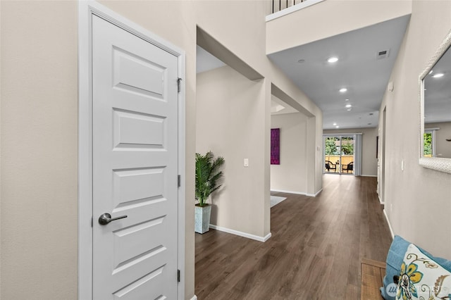corridor with wood finished floors, baseboards, and recessed lighting