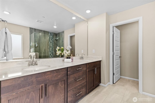 bathroom with a stall shower, double vanity, tile patterned floors, recessed lighting, and baseboards