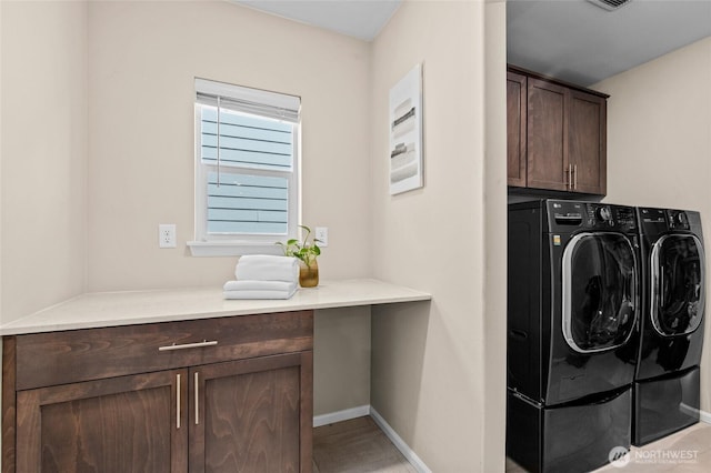 laundry area with washing machine and clothes dryer, cabinet space, baseboards, and light wood finished floors