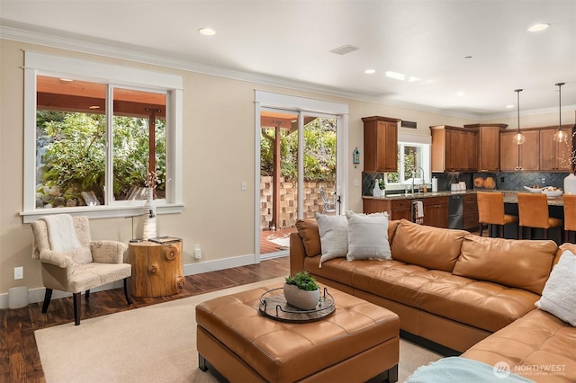 living room featuring light wood-type flooring, baseboards, recessed lighting, and ornamental molding