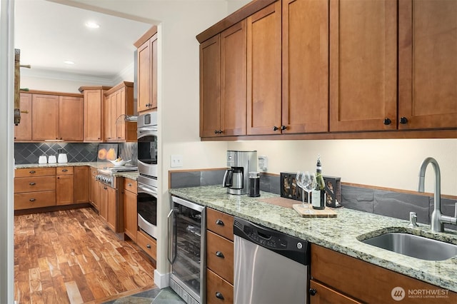 kitchen with beverage cooler, appliances with stainless steel finishes, a sink, ornamental molding, and tasteful backsplash