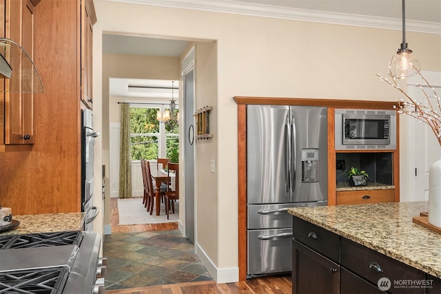 kitchen with stainless steel appliances, baseboards, crown molding, light stone counters, and pendant lighting