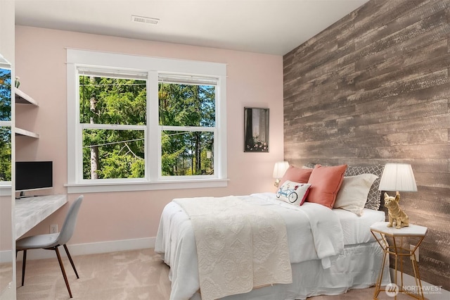 bedroom with wood walls, carpet floors, an office area, and baseboards
