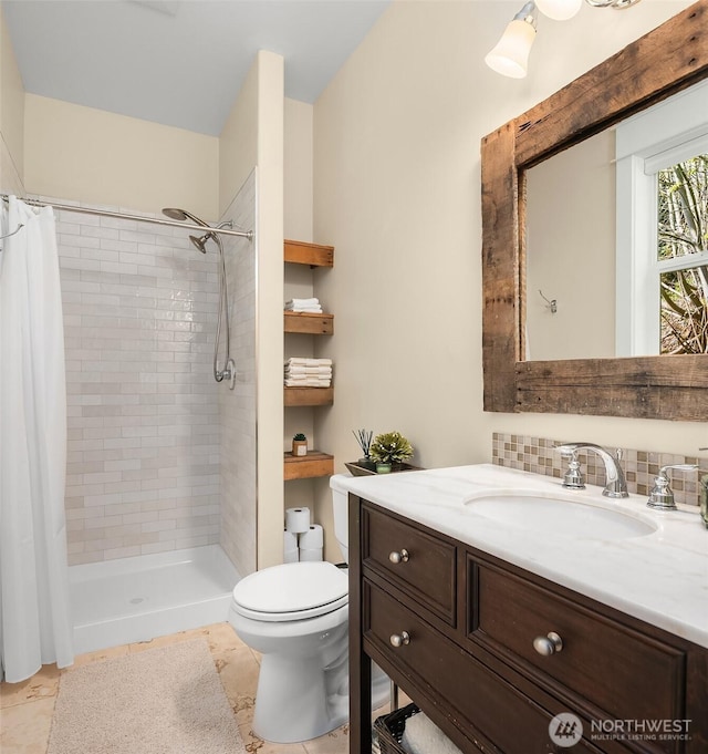full bath featuring toilet, a tile shower, and vanity