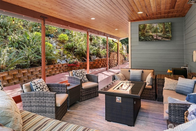 wooden deck featuring an outdoor living space with a fire pit