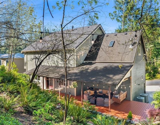 rear view of property featuring outdoor lounge area, a deck, and roof with shingles