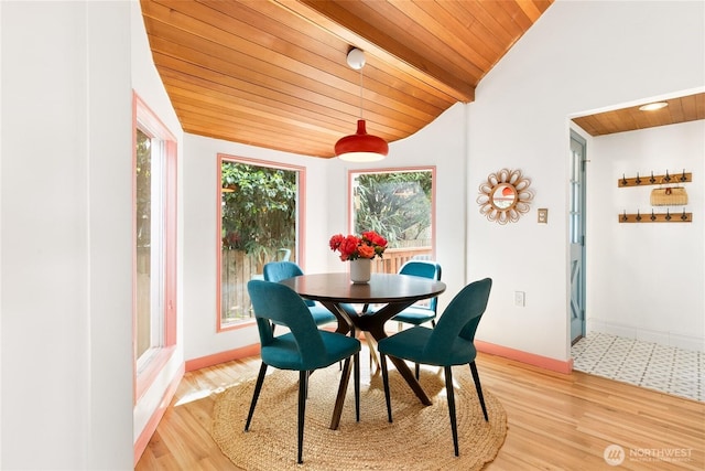 dining space with wood ceiling, lofted ceiling, light wood-type flooring, and baseboards