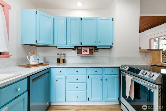 kitchen with electric range, blue cabinetry, dishwashing machine, and light countertops