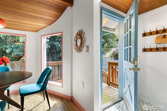 dining room featuring baseboards, wooden ceiling, and lofted ceiling