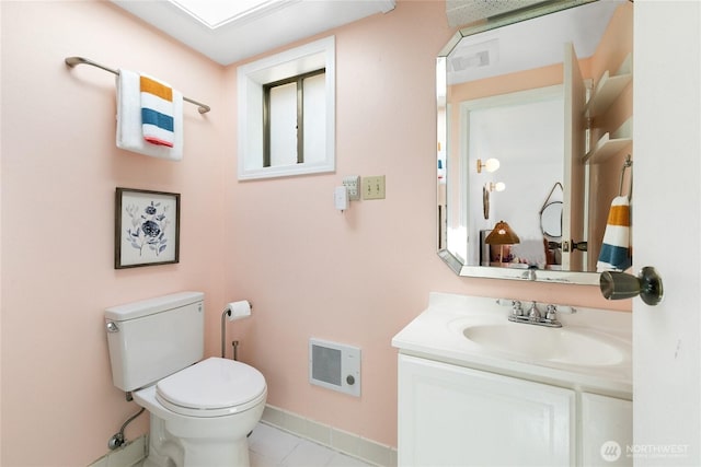 half bathroom featuring toilet, vanity, tile patterned floors, and baseboards