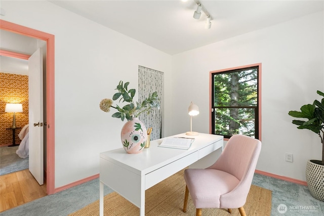 office area with light colored carpet, track lighting, and baseboards