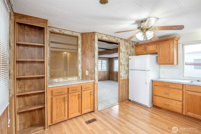 5705 113th Ave E Unit 68, Puyallup, WA 98372 - kitchen featuring freestanding refrigerator, light wood-style floors, light countertops, ceiling fan, and brown cabinets