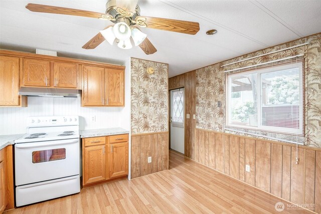 5705 113th Ave E Unit 68, Puyallup, WA 98372 - kitchen with white range with electric cooktop, under cabinet range hood, wallpapered walls, a wainscoted wall, and light countertops