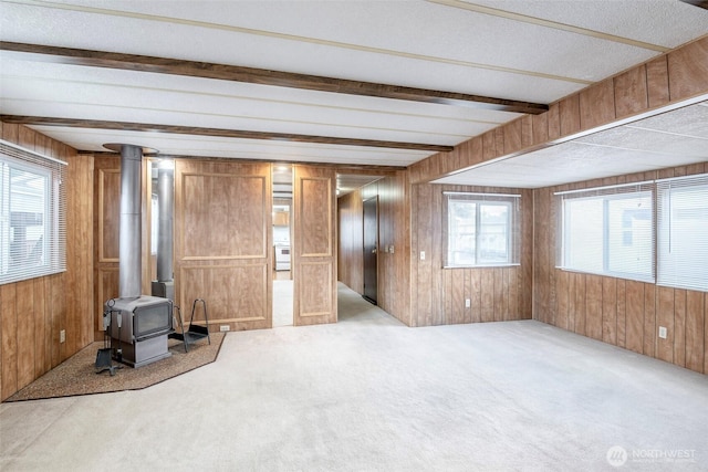 5705 113th Ave E Unit 68, Puyallup, WA 98372 - unfurnished living room featuring a wood stove, wood walls, and carpet