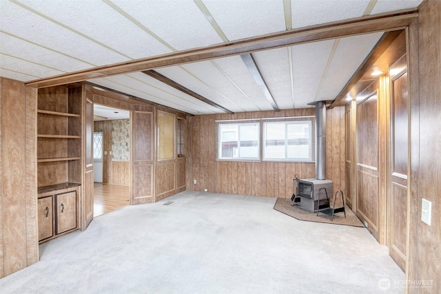 5705 113th Ave E Unit 68, Puyallup, WA 98372 - unfurnished living room featuring wooden walls, a wood stove, carpet, and a textured ceiling