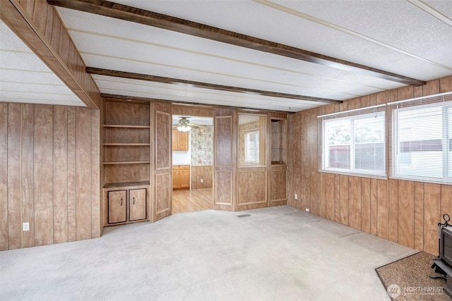 5705 113th Ave E Unit 68, Puyallup, WA 98372 - unfurnished living room with wood walls, beamed ceiling, carpet, and ceiling fan