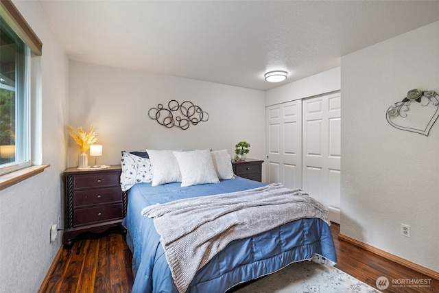 bedroom with wood finished floors, a closet, and baseboards