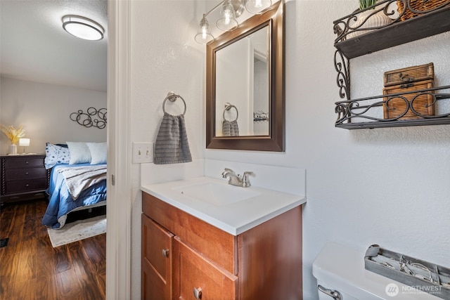 bathroom featuring wood finished floors, vanity, and toilet