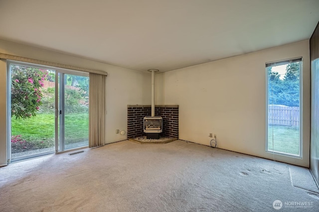 23238 21st Ave S, Des Moines, WA 98198 - unfurnished living room with plenty of natural light, carpet, a wood stove, and heating unit