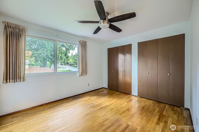 23238 21st Ave S, Des Moines, WA 98198 - unfurnished bedroom with two closets, light wood-style flooring, and ceiling fan