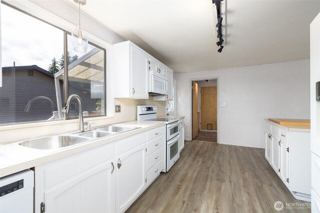 228 Skagit Way, La Conner, WA 98257 - kitchen featuring white appliances, a sink, white cabinets, light wood-style flooring, and light countertops