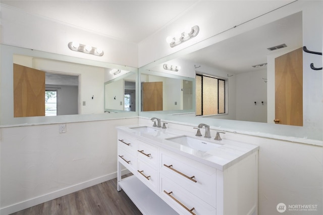 228 Skagit Way, La Conner, WA 98257 - bathroom with double vanity, wood finished floors, and baseboards