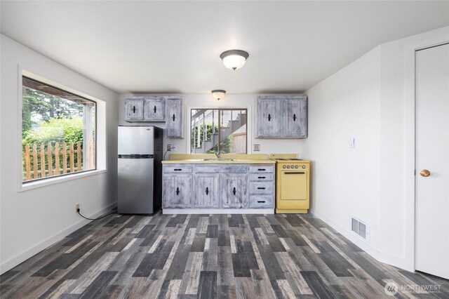 228 Skagit Way, La Conner, WA 98257 - kitchen featuring freestanding refrigerator, white stove, a sink, dark wood-style floors, and baseboards