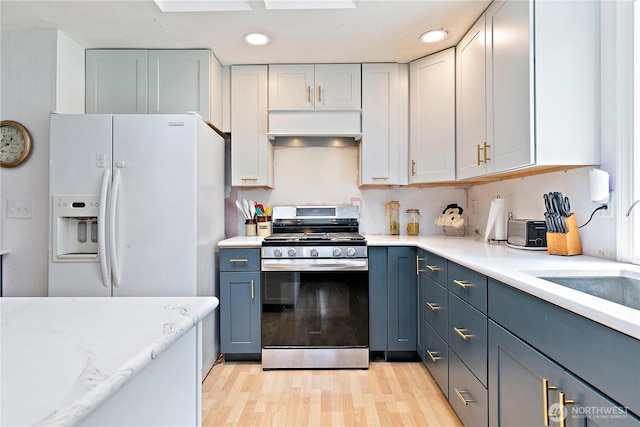 19414 112th Ave E, Graham, WA 98338 - kitchen with stainless steel range with gas cooktop, white fridge with ice dispenser, custom range hood, a sink, and light wood-style floors