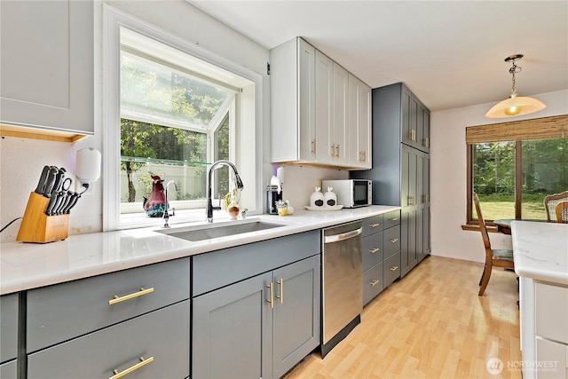19414 112th Ave E, Graham, WA 98338 - kitchen featuring stainless steel dishwasher, gray cabinets, a sink, and light wood-style floors