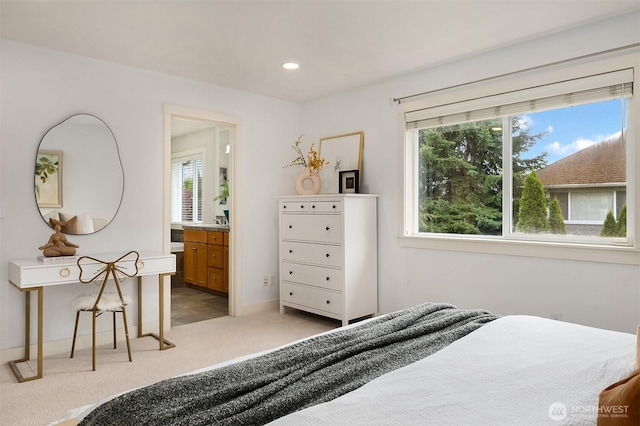 bedroom featuring light carpet, recessed lighting, baseboards, and ensuite bathroom