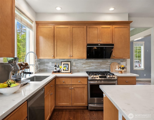 kitchen featuring stainless steel gas range, a sink, black dishwasher, plenty of natural light, and recessed lighting