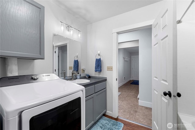 250 Lakefront Dr, Orondo, WA 98843 - washroom featuring washer / clothes dryer, cabinet space, dark tile patterned flooring, and baseboards