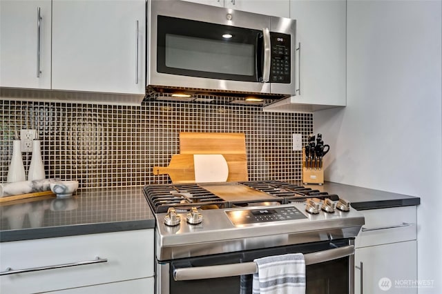 4216 30th Ave SW, Seattle, WA 98126 - kitchen view of stainless steel appliances, tasteful backsplash, white cabinetry, and dark countertops