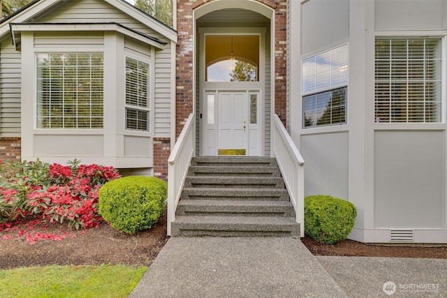 view of exterior entry featuring brick siding
