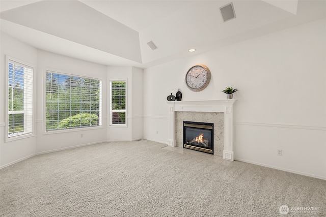 unfurnished living room with carpet, a high end fireplace, baseboards, and recessed lighting