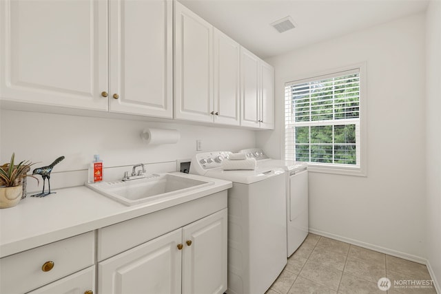 laundry area with cabinet space, separate washer and dryer, baseboards, and light tile patterned floors
