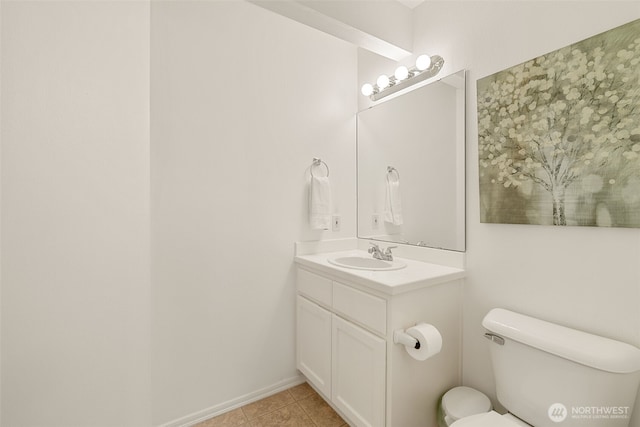 bathroom with toilet, vanity, and tile patterned floors