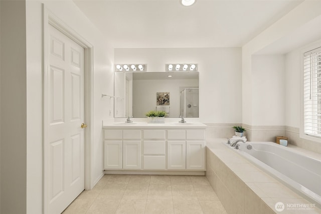 bathroom with a shower stall, tile patterned floors, a bath, and double vanity