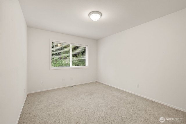 carpeted empty room featuring baseboards