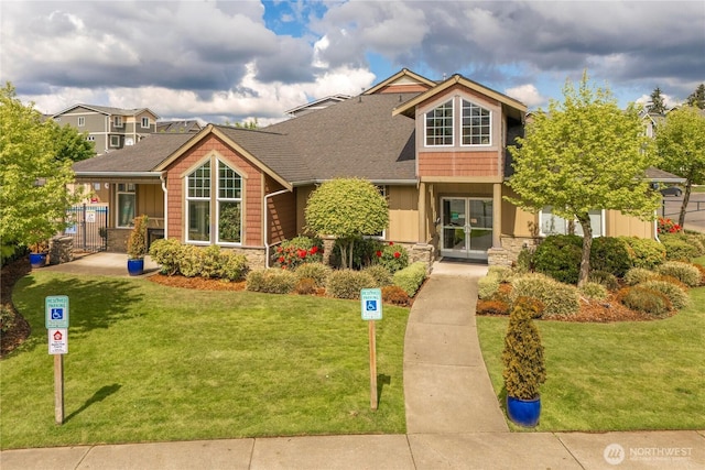 13426 97th Ave E Unit 303, Puyallup, WA 98373 - view of front of property with stone siding, a front lawn, and a shingled roof
