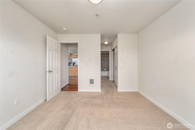 13426 97th Ave E Unit 303, Puyallup, WA 98373 - unfurnished bedroom with light colored carpet, baseboards, and a closet