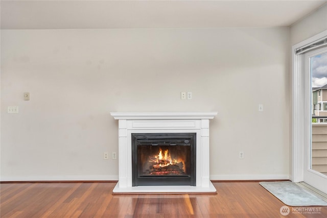 13426 97th Ave E Unit 303, Puyallup, WA 98373 - detailed view of wood finished floors, a glass covered fireplace, and baseboards
