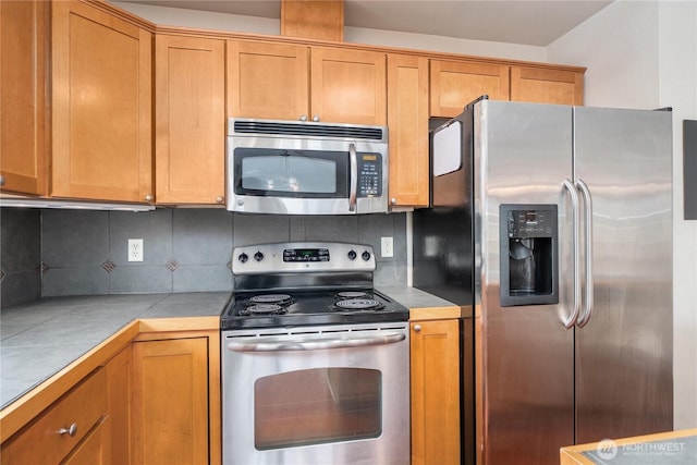 13426 97th Ave E Unit 303, Puyallup, WA 98373 - kitchen with stainless steel appliances, backsplash, and brown cabinets