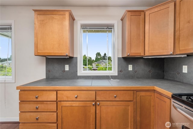 13426 97th Ave E Unit 303, Puyallup, WA 98373 - kitchen with tile counters, tasteful backsplash, and brown cabinets